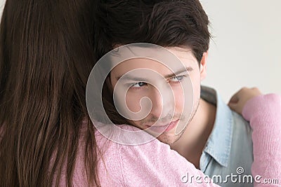 Thoughtful young man embracing lady looking away, lost in though Stock Photo