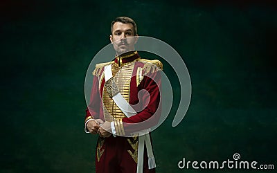 Young man as Nicholas II on dark green background. Retro style, comparison of eras concept. Stock Photo