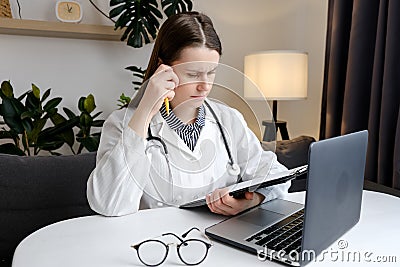 Thoughtful young woman doctor look at office computer screen ponder on establishing correct diagnosis choose treatment. Hard Stock Photo