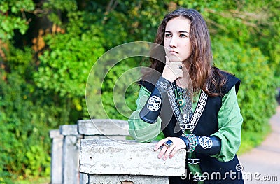 Thoughtful young woman in medieval suit Stock Photo