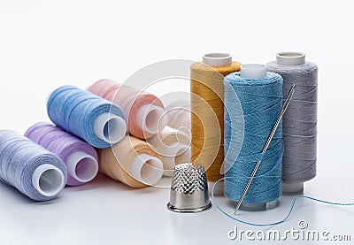 Threads of different colors for needlework. Thimble and needle. Stock Photo