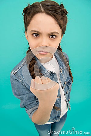 Threatening with fist. Angry child shake fist grey background. Beauty look of child girl. Small child in casual wear Stock Photo