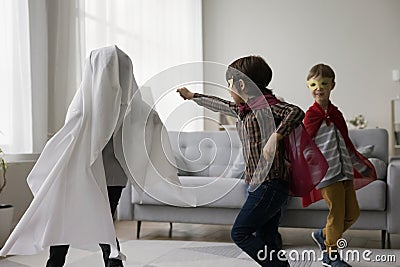 Three active naughty boys wearing super hero costumes Stock Photo