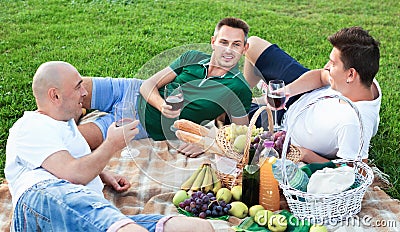 Three adult men enjoying picnic outdoors on summer day Editorial Stock Photo