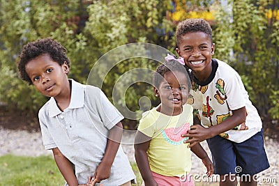 Three African American kids in a garden looking to camera Stock Photo