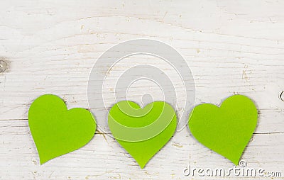 Three apple green hearts on white shabby style wooden background Stock Photo