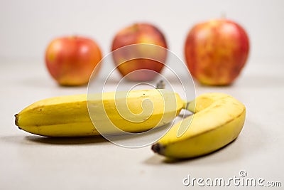 Three Apples and Two Bananas on a Gray White Grey Marble Slate Background Stock Photo