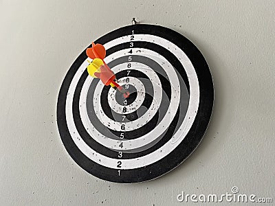 Three arrows stuck in a black and white dartboard Stock Photo