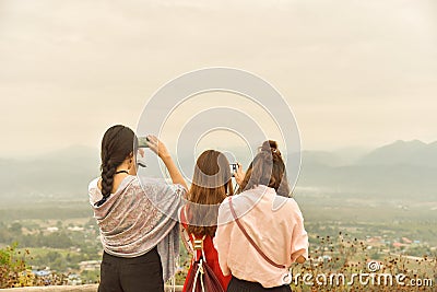 Three of asian ladies enjoy mountain view,use smart phone capture view,travel concept. Editorial Stock Photo