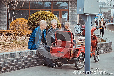 Three asian old men sitting on side walk in street of Beijing Editorial Stock Photo