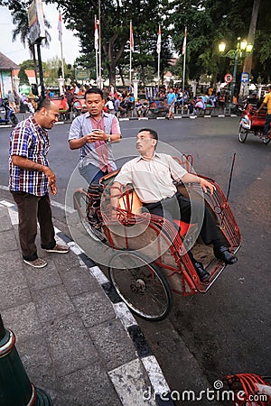 three Asian people riding a means of transportation called Editorial Stock Photo