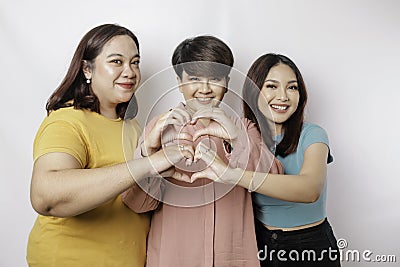 Three Asian women feel happy and a romantic shapes heart gesture expresses tender feelings, close friendship concept Stock Photo