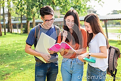 Three Asian young campus students enjoy tutoring and reading boo Stock Photo