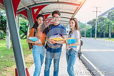 Three Asian young campus students enjoy tutoring and reading boo Stock Photo