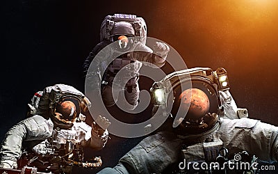 Three astronauts in front of Mars. Elements of the image are furnished by NASA Stock Photo