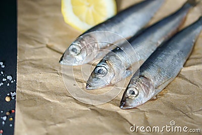 Three Atlantic herrings on craft paper. Stock Photo