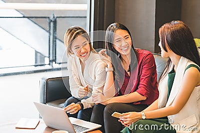 Three Asian girls chatting on sofa at cafe or coffee shop together. Gossip talks, Casual lifestyle with gadget technology concept Stock Photo
