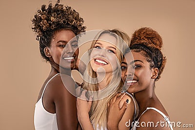 Three Beautiful Diverse Girls Posing together, smiling and looking at camera Stock Photo