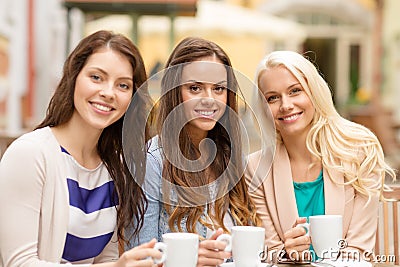 Three beautiful girls drinking coffee in cafe Stock Photo
