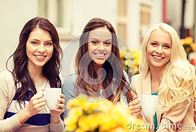 Three beautiful girls drinking coffee in cafe Stock Photo