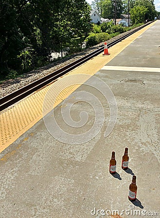Three Beer Bottles on a Train Platform Editorial Stock Photo
