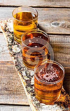 Three beers on birch stand. On a wooden table. Stock Photo