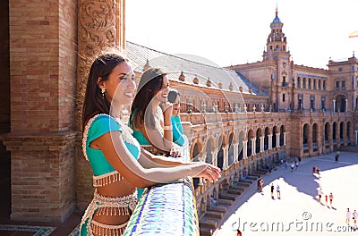 Three belly dancers on a balcony looking out and pointing to the horizon. The dancers are beautiful and adult. Concept of dance Stock Photo