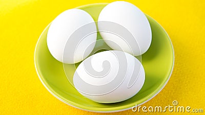 Three boiled eggs on green plate Stock Photo