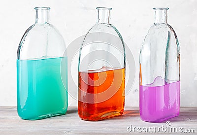 Three bottles with watercolour solutions on gray Stock Photo