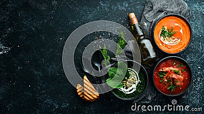 Three bowls with colored soup. Spinach, tomato and carrot soup. Healthy food. Stock Photo