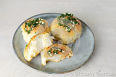 Three buns with garlic and dill sauce with oil in a gray plate. Preparation of pampushky (Pampushky) Stock Photo