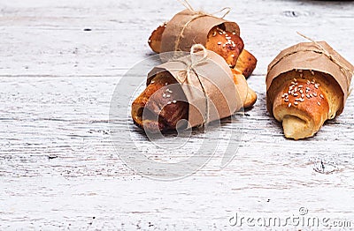 Three buns wrapped in a white wooden background closeup Stock Photo