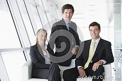 Three businesspeople sitting in office lobby Stock Photo