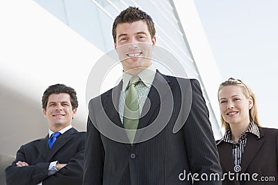 Three businesspeople standing outdoors by building Stock Photo