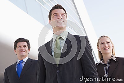 Three businesspeople standing outdoors by building Stock Photo