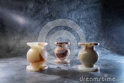 three candlesticks made of onyx on a gray background Stock Photo