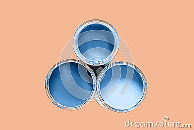 Three cans filled paint of classic blue color isolated on Peach Quartz trendy color background Stock Photo