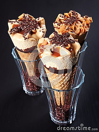 Three caramel ice cream cones on dark background Stock Photo