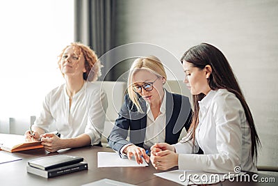 Three caucasian female students using laptop, working on pc, online education. Stock Photo