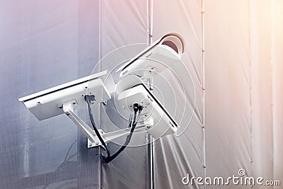 Three CCTV cameras on corner of building under restoration or renewal outdoors. Security cameras on wall of construction building Stock Photo