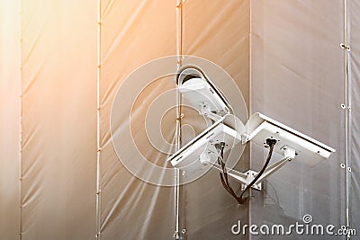 Three CCTV cameras on corner of building under restoration or renewal outdoors. Security cameras on wall of construction building Stock Photo