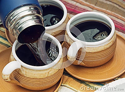 Three ceramic cups and thermos with coffee Stock Photo