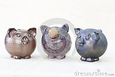 Three ceramic figurines in the form of a pig stand next to each other Stock Photo