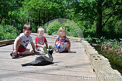 Three children and a bird Stock Photo