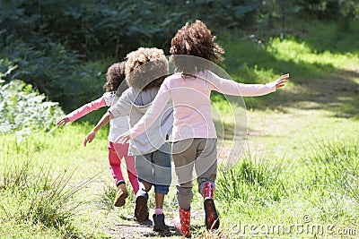 Three Children Playing In Woods Together Stock Photo