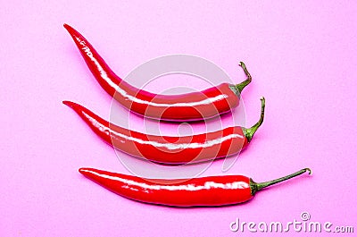 Three chilies on a violet pastel background Stock Photo