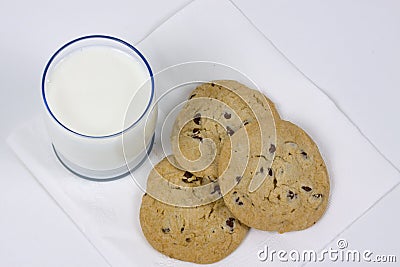 Three chocolate chip cookies and glass of milk Stock Photo