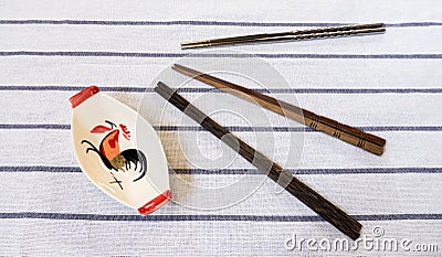 Three Chopsticks and Traditional Thai Chicken Bowl on White Table Stock Photo
