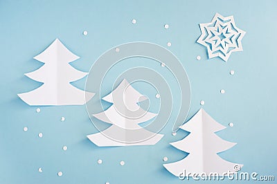 Three Christmas trees made of paper applications on a blue background. Stock Photo