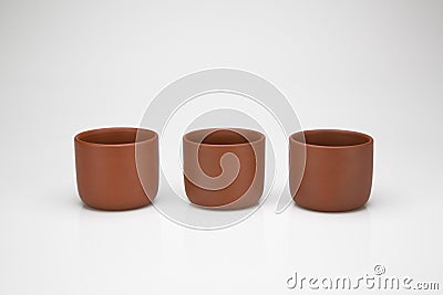 Three clay cups in a row, isolated on white background Stock Photo